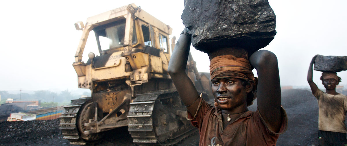 A worker carries coal in Jharia coal mine. India's coal building bubble has also seen a focus on new mining.