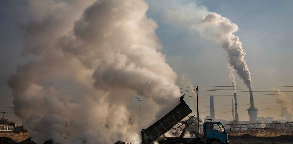 INNER MONGOLIA, CHINA - NOVEMBER 03: A Chinese labourer unloads waste coal and stone as smoke and steam rises next to an unauthorized steel factory on November 3, 2016 in Inner Mongolia, China. To meet China's targets to slash emissions of carbon dioxide, authorities are pushing to shut down privately owned steel, coal, and other high-polluting factories scattered across rural areas. In many cases, factory owners say they pay informal "fines" to local inspectors and then re-open. The enforcement comes as the future of U.S. support for the 2015 Paris Agreement is in question, leaving China poised as an unlikely leader in the international effort against climate change. U.S. president-elect Donald Trump has sent mixed signals about whether he will withdraw the U.S. from commitments to curb greenhouse gases that, according to scientists, are causing the earth's temperature to rise. Trump once declared that the concept of global warming was "created" by China in order to hurt U.S. manufacturing. China's leadership has stated that any change in U.S. climate policy will not affect its commitment to implement the climate action plan. While the world's biggest polluter, China is also a global leader in establishing renewable energy sources such as wind and solar power. (Photo by Kevin Frayer/Getty Images)